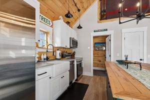 a kitchen with white cabinets and a wooden floor at Maple Chalet in Morrisville +20 photos