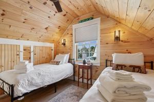 a bedroom with two beds in a wooden cabin at Maple Chalet in Morrisville