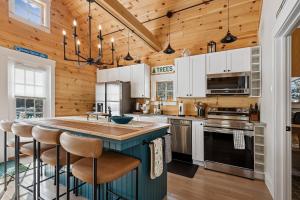 a kitchen with white cabinets and a blue island with bar stools at Maple Chalet in Morrisville