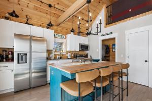 a kitchen with white cabinets and a blue island with bar stools at Maple Chalet in Morrisville