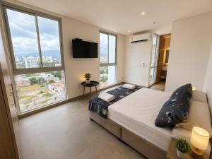 a bedroom with a large bed and large windows at Santamarta, marina centro historico in Santa Marta