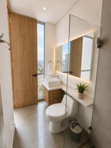 a bathroom with a toilet and a sink and a mirror at Santamarta, marina centro historico in Santa Marta