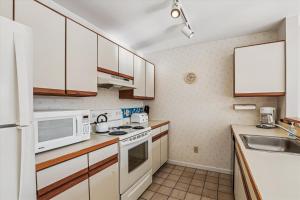 a kitchen with white appliances and wooden cabinets at Mountainside Condo J202 in Stowe