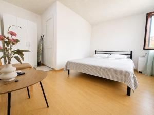 a white bedroom with a bed and a table at MaVi House in Kutaisi