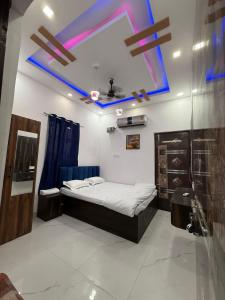 a bedroom with a bed and a blue ceiling at Roshan's INN Hotel in Patna