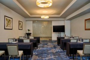 a room with tables and chairs and a projection screen at DoubleTree by Hilton Irvine Spectrum in Irvine