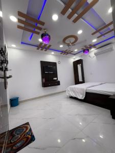 a bedroom with a bed and a flat screen tv at Roshan's INN Hotel in Patna +4 photos