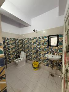 a bathroom with a toilet and a sink at Roshan's INN Hotel in Patna