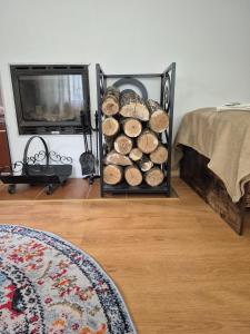 a rack of logs in a room with a bed at Siedlisko Bliss Garden Retreat House ZielonoMi in Lengenquell