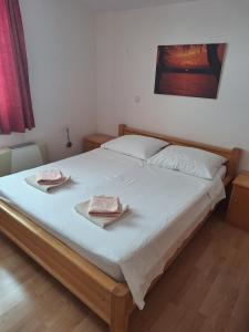 a bedroom with a bed with two towels on it at Apartments Primosten in Primošten
