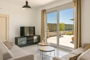 a living room with a couch and a tv at Villa George by Villa Select in Lourdata