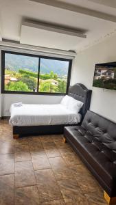 a bedroom with a bed and a couch and a large window at Hotel PUENTE PIEDRA PARK in Villa de Leyva +48 photos