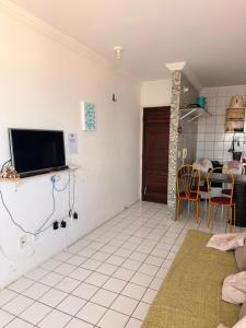 a living room with a tv and a table at Flat em Sao Jose da Coroa Grande in São José da Coroa Grande