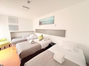 three beds in a room with white walls at Barranco Boutique Hotel by 3B in Lima
