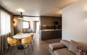 a living room with a table and chairs and a kitchen at Avita suites Ortisei in Ortisei