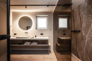 a bathroom with a sink and a mirror at Avita suites Ortisei in Ortisei