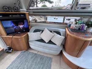 a room with a couch and a tv in a boat at Midnight business in Thorpe