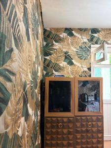 a bedroom with a wall with a wallpaper with leaves at Elasia in Martvili