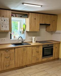 a kitchen with wooden cabinets and a sink and a window at Górna Residence&Rooms in Grudziądz