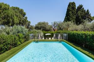 a swimming pool with a table and chairs in a garden at Villa Collina in Giardini Naxos