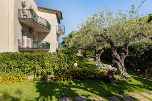 a building with a tree and a bench in a yard at Villa Collina in Giardini Naxos