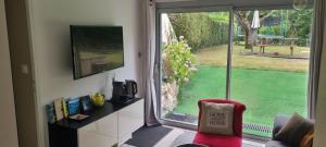 a living room with a window with a view of a yard at TISHA in Saint-Jorioz