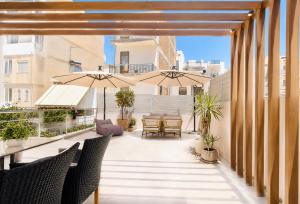an outdoor patio with umbrellas and a table and chairs at Casa Enetiko in Chania