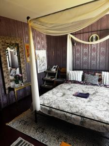 a bedroom with a canopy bed and a mirror at Romantic Studio Suite with Sauna in Pyussi