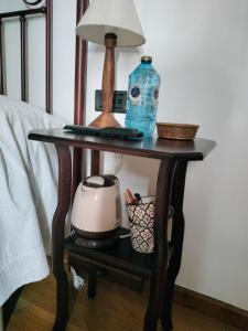 a table with a lamp and a bottle on it at Casa Benaxo Ribeira Sacra in Currelos