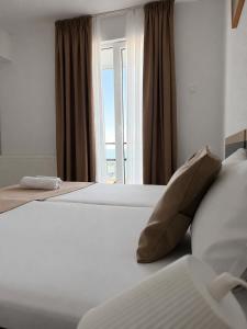 a hotel room with two beds and a window at Hotel Cosmos in Eforie Sud