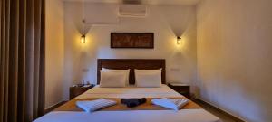 a bedroom with a bed with two towels on it at Moksha Villa-Hostel Kandy in Kandy