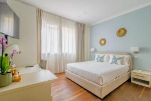 a bedroom with a white bed and a white desk at B&B H68 in Alassio +22 photos