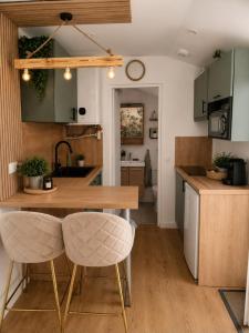 a kitchen with a wooden table and two chairs at La Cachette - Studio Nature - Terrasse Privée in Corbeil-Essonnes