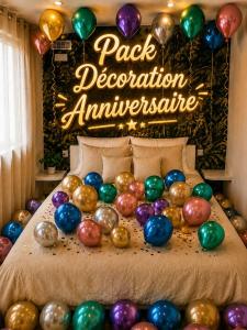 a bed with a bunch of balloons on it at La Cachette - Studio Nature - Terrasse Privée in Corbeil-Essonnes +3 photos