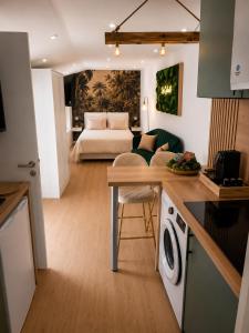 a kitchen and living room with a couch and a bed at La Cachette - Studio Nature - Terrasse Privée in Corbeil-Essonnes