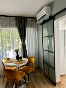 a dining room with a table and chairs and a window at Modern studio D-va N in Zalău