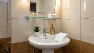 a bathroom with a white sink and a mirror at Kalamata Penthouse By PAVLOS in Kalamata