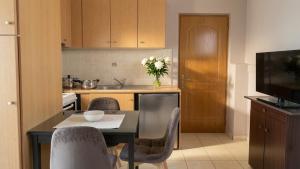 a kitchen with a table and chairs and a television at Kalamata Penthouse By PAVLOS in Kalamata