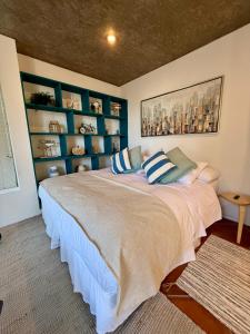 a bedroom with a large bed with blue shelves at Hotel Green en Marbella in Maitencillo