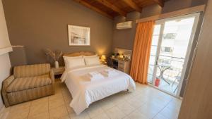 a bedroom with a bed and a chair and a window at Kalamata Penthouse By PAVLOS in Kalamata