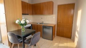 a kitchen with a table with a vase of flowers on it at Kalamata Penthouse By PAVLOS in Kalamata +12 photos