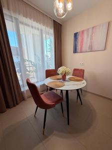 a dining room with a table and chairs and a window at CasaBlanca vendégház in Abádszalók