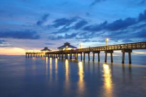 a pier on the water with a cloudy sky at Little EsCape in Matlacha
