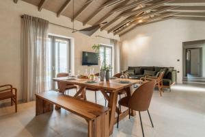 a living room with a wooden table and chairs at Villa Ouranos by Villa Select in Fiskardo