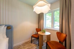 a room with a bed and a table and chairs at The Meadowmere Resort in Ogunquit