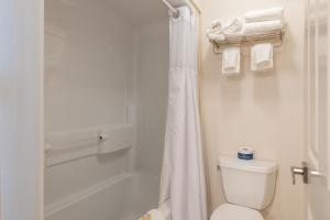 a white bathroom with a toilet and a shower at The Meadowmere Resort in Ogunquit