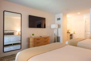 a bedroom with two beds and a large mirror at The Meadowmere Resort in Ogunquit