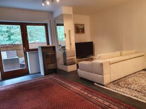 a living room with a white couch and a television at Sleep & Go - Sechsbettzimmer inkl 2 Luftbetten mit Gemeinschaftsbad in Sonthofen