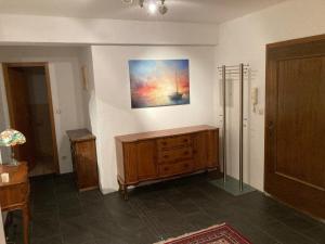 a room with a wooden cabinet and a painting on the wall at Sleep & Go - Sechsbettzimmer inkl 2 Luftbetten mit Gemeinschaftsbad in Sonthofen
