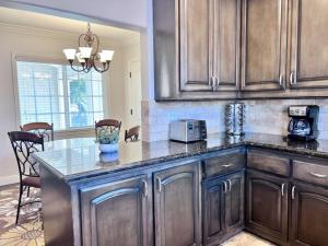 a kitchen with wooden cabinets and a counter top at Gorgeous Pool Home 1/2 Mile Walk to Disney in Anaheim